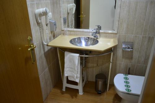 a bathroom with a sink and a toilet at Hotel Alda Centro Oviedo in Oviedo