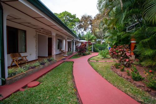 a red path in front of a house at Hotel La Rosa de America in Alajuela City