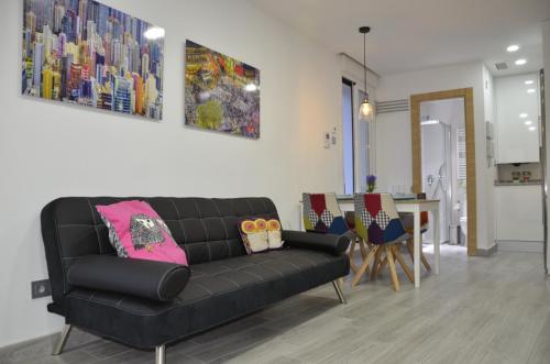 a living room with a black couch and a table at CHECK-IN 24H NUEVO Único WIFI FAMILIAR Centro Planta 3 in Zaragoza