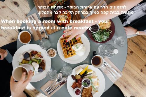 a table topped with plates of food and drinks at The Roof - By Sea Land Suites in Tel Aviv
