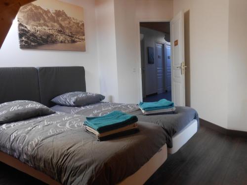 a bedroom with a bed with two towels on it at Le Chalet Carpe Diem in Le Bourg-dʼOisans