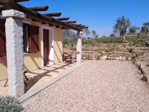 un porche de una casa con una silla en Agriturismo Donnolù, en Tertenìa