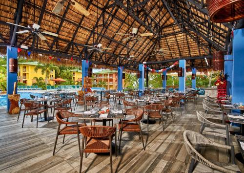 ein Restaurant mit Tischen und Stühlen und einem Pool in der Unterkunft Grand Decameron Panama, A Trademark All Inclusive Resort in Playa Blanca