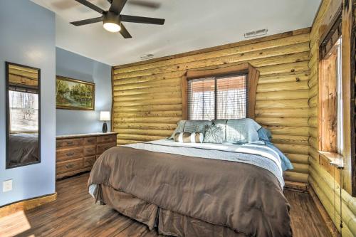 1 dormitorio con 1 cama con paredes de madera y techo en Stylish Creekside Cabin with Fire Pit Near Wineries!, en Pittsville