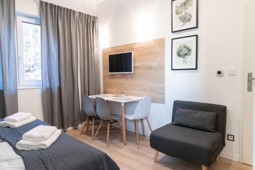 a small room with a table and chairs and a bed at Apartamenty Pod Zamkiem w Janowcu in Janowiec