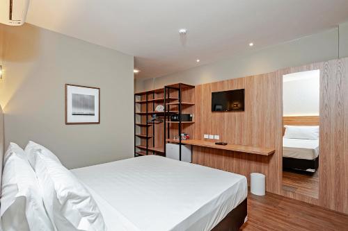 a hotel room with a bed and a tv at Slaviero Curitiba Aeroporto in São José dos Pinhais