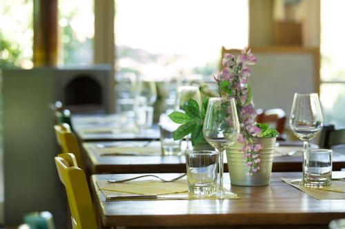 a wooden table with glasses and flowers on it at Alpaca country house in Pontedera
