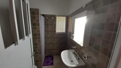 een badkamer met een wastafel, een toilet en een raam bij LOS TATOS con cochera in Villa María