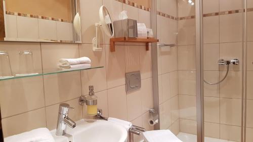 a bathroom with a sink and a shower at Winzerhof Gietzen in Hatzenport