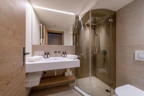 a bathroom with a sink and a shower at Brunnenhof Luxury Apartments in Lech am Arlberg