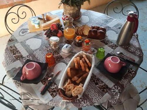a table with a breakfast of food and orange juice at La mare aux grenouilles in Bruailles