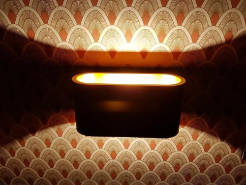 a light hanging on a wall with a ceiling at B&B The Street Lodge in Liège