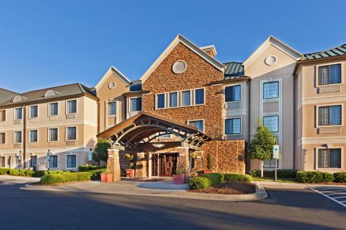 a row of apartment buildings with a building at Staybridge Suites - Charlotte Ballantyne by IHG in Charlotte