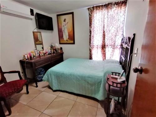 1 dormitorio con cama, mesa y ventana en Depa Centrico Mazatlan a 2 cuadras de a Playa, Central, Acuario., en Mazatlán