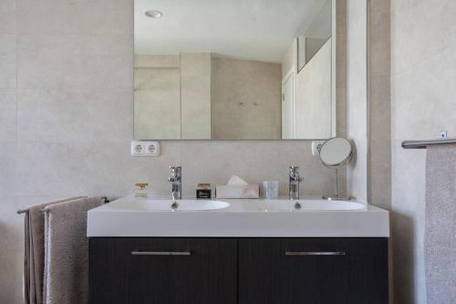 een badkamer met een witte wastafel en een spiegel bij Oden 2 in Altea