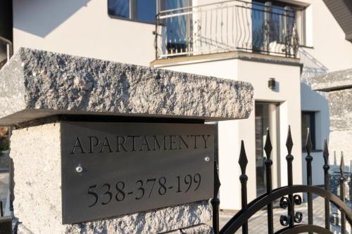 a sign in front of a building at Apartamenty Pod Zamkiem w Janowcu in Janowiec