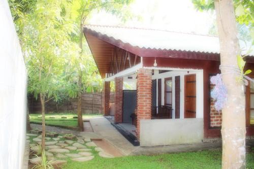 a small house with a pathway leading to it at Green Cottage in Anuradhapura
