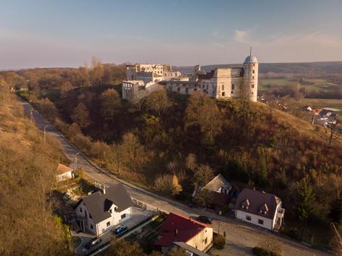 a castle on top of a hill with houses at Apartamenty Pod Zamkiem w Janowcu in Janowiec