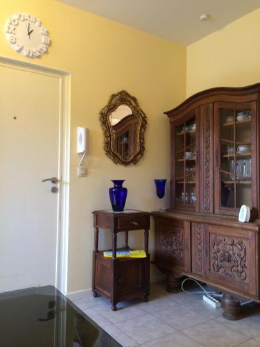 a room with a wooden cabinet and a clock on the wall at Appartements Brussel in Brussels