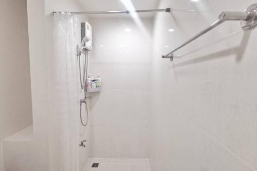 a white bathroom with a shower with a shower curtain at Feel like Home in Bangna