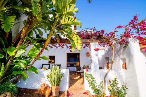 a white house with plants in the yard at Hotel Rural & Spa Can Curreu in Sant Carles de Peralta