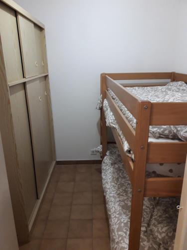 Cette petite chambre comprend des lits superposés et une armoire. dans l'établissement Plage et soleil, à Les Salins dʼHyères