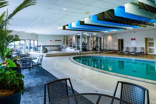 a swimming pool in a hotel with tables and chairs at Best Western Vista Inn at the Airport in Boise
