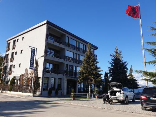 a white building with two dogs in front of it at Hotel Millennium in Pogradec