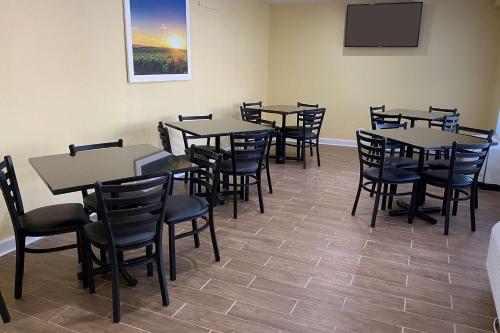 a dining room with tables and chairs and a tv at Days Inn by Wyndham Atlanta/Southlake/Morrow in Morrow