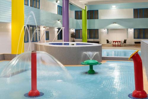 a pool with a water slide in a building at Travelodge Hotel by Wyndham Saskatoon in Saskatoon