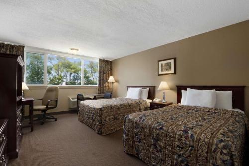 una camera d'albergo con due letti e una finestra di Travelodge by Wyndham Richmond Hill a Richmond Hill