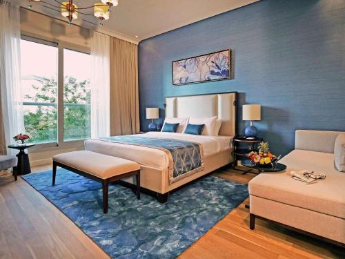 a bedroom with a large bed and a couch at Rixos The Palm Hotel & Suites - Ultra All Inclusive in Dubai