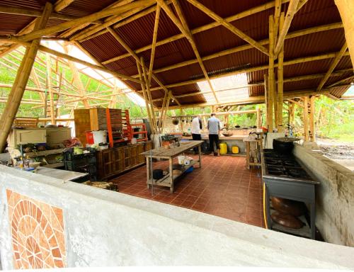 una cucina con due persone in piedi in un edificio di Río Muchacho Organic Farm a Bahía de Caráquez