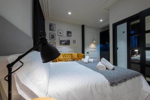 a bedroom with a white bed and a lamp at Barbarossa Suites Plaza de España in Merida