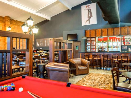 a billiard room with a pool table and a bar at Ibis São Carlos in São Carlos