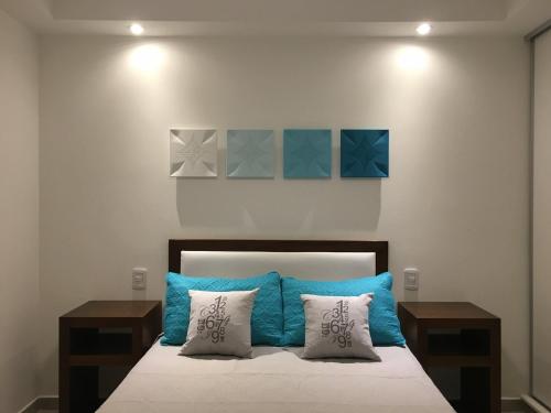1 dormitorio con 1 cama con almohadas azules y grises en Septiembre en Colón