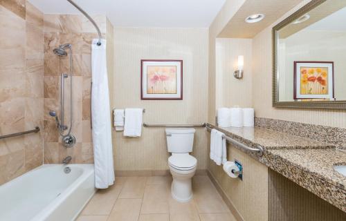 a bathroom with a toilet and a tub and a sink at Holiday Inn Express San Diego - Sea World Area, an IHG Hotel in San Diego