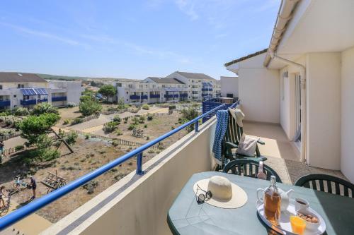 a table on a balcony with a view of the city at Résidence Pierre & Vacances Bleu Marine in Lacanau-Océan
