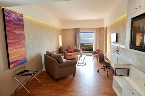 a living room with two couches and a painting on the wall at Ramada Plaza by Wyndham Thraki in Alexandroupoli