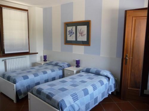 een slaapkamer met 2 bedden en een foto aan de muur bij il PoetaContadino in Casalbuttano