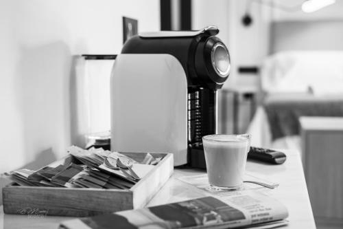 a coffee maker and a glass of milk on a counter at Barbarossa Suites Plaza de España in Merida