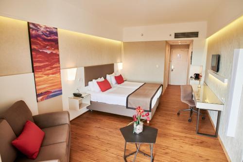 a hotel room with a bed and a couch at Ramada Plaza by Wyndham Thraki in Alexandroupoli