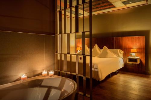 a bedroom with a bed and a tub in a room at Hotel La Casueña in Lanuza