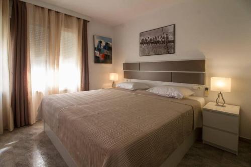 a bedroom with a large bed and two lamps at Santa Elena in Altea