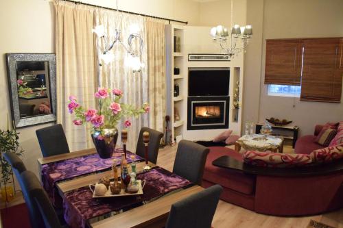 een woonkamer met een eettafel en een woonkamer met een open haard bij Five stars in Trikala in Tríkala