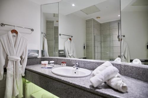 a bathroom with a sink and a mirror at Ramada Plaza by Wyndham Thraki in Alexandroupoli