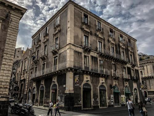 un gran edificio con gente caminando delante de él en Otto Biscari, en Catania
