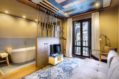a living room with a couch and a tv and a tub at Hotel La Casueña in Lanuza
