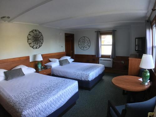 um quarto de hotel com duas camas e uma mesa em Bay Top Motel em Weirs Beach