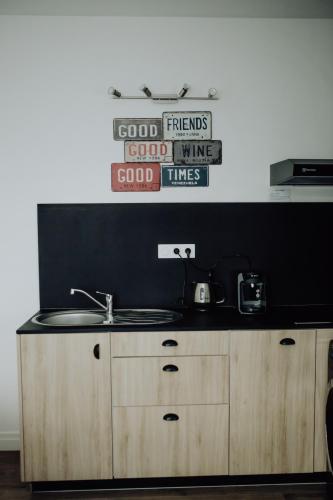 a kitchen with a sink and a sign on the wall at Les Terrasses sur Seine in Vernon